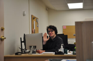 Adam sitting at desk